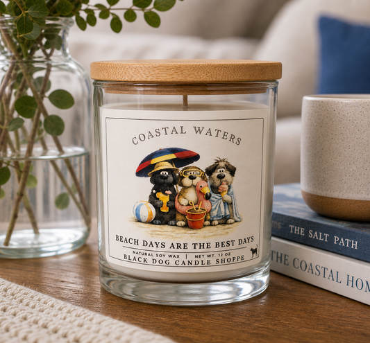Coastal Waters soy candle in clear glass jar with bamboo lid, featuring dog beach illustration, styled on wooden table with books and greenery