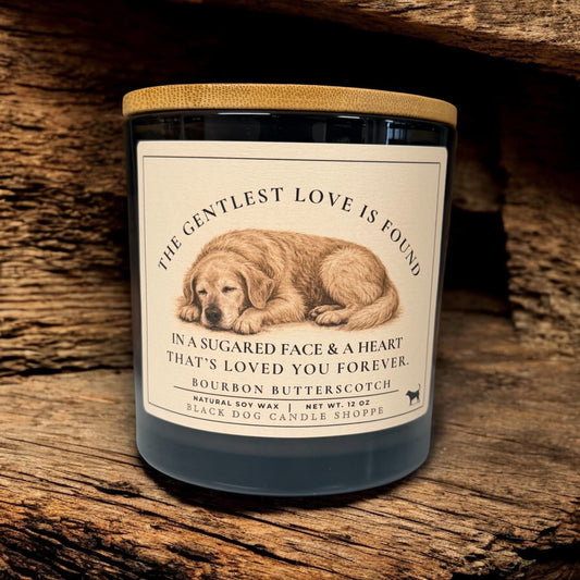 Dog sympathy soy candle in matte black jar with bamboo lid, featuring sleeping dog illustration and memorial message, styled on rustic wood background