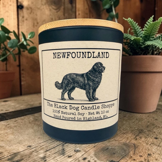 Newfoundland dog candle in matte black jar with bamboo lid, vintage illustration label, hand poured soy candle on rustic wood surface